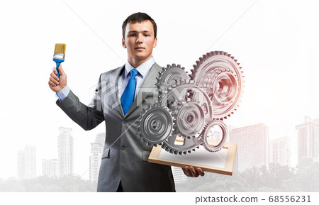 Creative businessman painter holding paintbrush 68556231