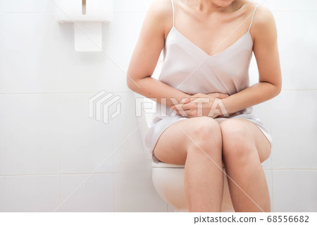 Women wearing white skirts pajamas, Sitting on the toilet Hand holding the stomach,health care,urinary , infection, tract,crotch incontinence , urinary , bladder,dysmenorrhea concept 68556682