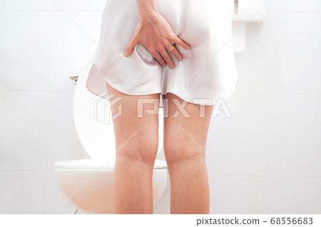 Women wearing white skirts pajamas, Sitting on the toilet Hand holding the stomach,health care,urinary , infection, tract,crotch incontinence , urinary , bladder,dysmenorrhea concept 68556683