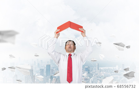 Senior businessman holding open book 68556732
