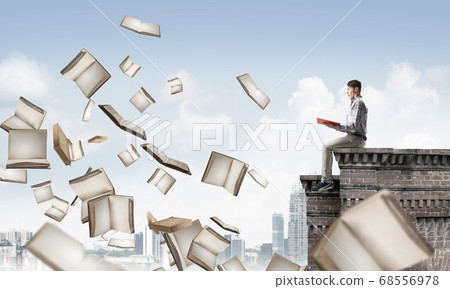 Man reading book and many of them flying in air Man reading book and many of them flying in air 68556978