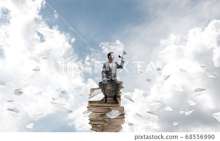 Businessman announcing something in loudspeaker and paper planes fly around Businessman announcing something in loudspeaker and paper planes fly around 68556990