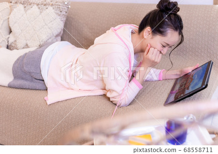 Woman watching travel photos on tablet Woman watching travel photos on tablet 68558711