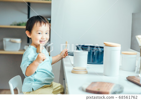 A little boy is smiling and cooking in the kitchen kids cooking 68561762
