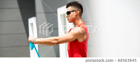 Banner of sports man doing shoulder front raise exercise with resistance band Banner of sports man doing shoulder front raise exercise with resistance band 68563645