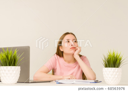Tired overworked young intern woman working with a Tired overworked young intern woman working with a 68563976