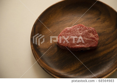 Raw thick beef fillet steak on acacia plate Raw thick beef fillet steak on acacia plate 68564983