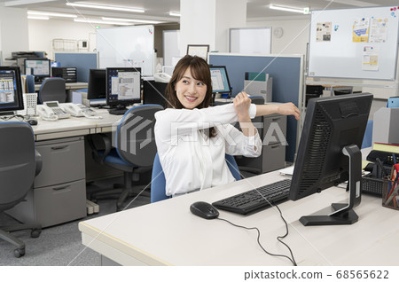 Young woman stretching during work 68565622
