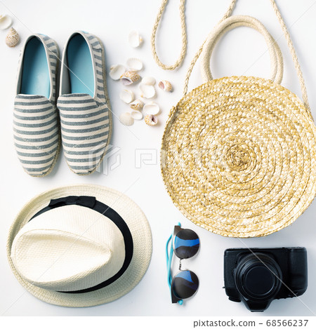 Flat lay traveler accessories on white background with straw hat, summer shoes, camera, bag and sunglasses. Flat lay traveler accessories on white background with straw hat, summer shoes, camera, bag and sunglasses. 68566237