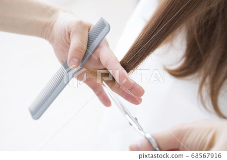 The hand of a hairdresser who cuts hair 68567916