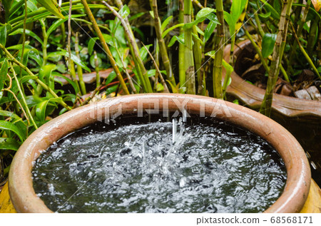 Rain Pouring Down from the Rooftop to Pottery Jar. 68568171