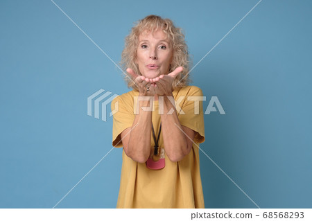 Beautiful senior woman blows kiss, demonstrates her good feelings Beautiful senior woman blows kiss, demonstrates her good feelings 68568293