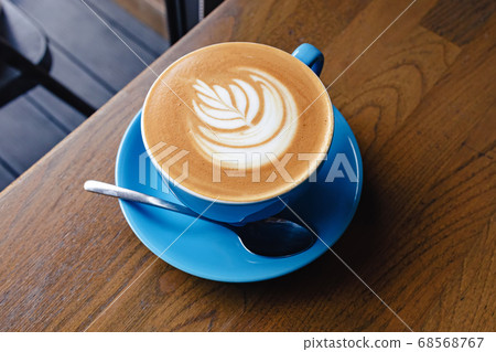 Cup of fresh cappuccino with latte art on the wooden table 68568767