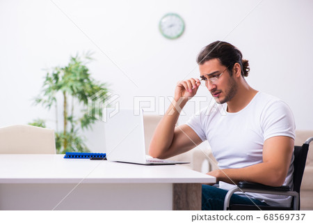 Young disabled man working from house 68569737
