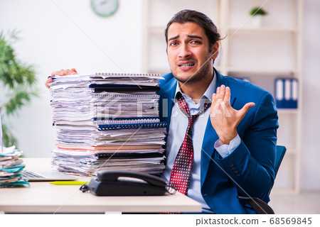 Young male employee unhappy with excessive work 68569845