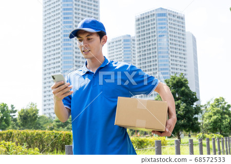 A male driver of a courier that delivers luggage A male driver of a courier that delivers luggage 68572533