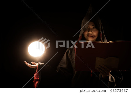 sorceress in black coat cast a spell calling lighting ball from hand on black background sorceress in black coat cast a spell calling lighting ball from hand on black background 68573487