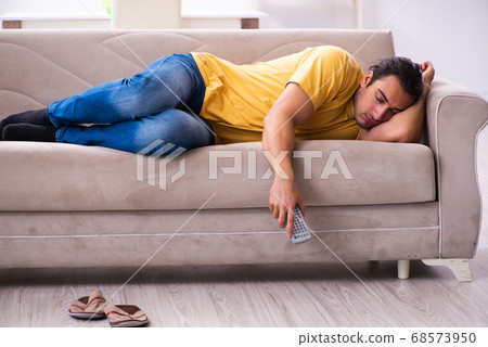 Young man watching tv at home 68573950