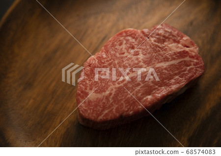 Raw thick beef fillet steak on acacia plate Raw thick beef fillet steak on acacia plate 68574083
