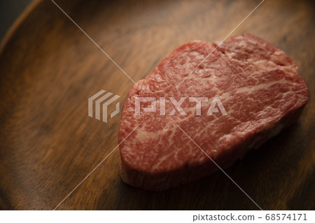 Raw thick beef fillet steak on acacia plate 68574171