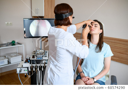 Female otolaryngologist and patient in office, exa Female otolaryngologist and patient in office, exa 68574290
