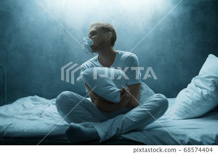 Psycho man hugs pillow in bed, insomnia horror 68574404