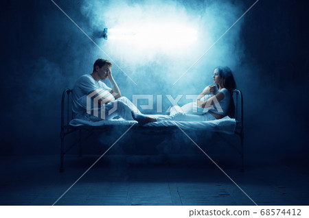 Crazy man and woman sitting in bed, psychedelics 68574412