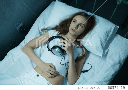 Crazy woman listens to music in bed, psychedelic 68574419