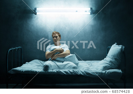 Sad psycho man sitting alone in bed, psychedelic 68574428