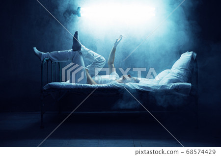 Psycho man in bed, dark smoky room on background 68574429