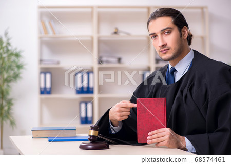 Young male judge working in courthouse 68574461
