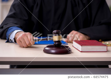 Young male judge working in courthouse Young male judge working in courthouse 68574475
