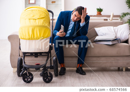 Young businessman looking after newborn at home 68574566