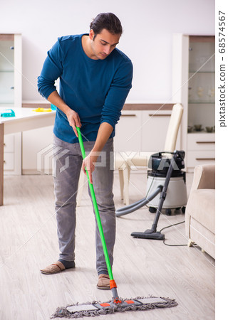 Young man husband doing housework at home 68574567