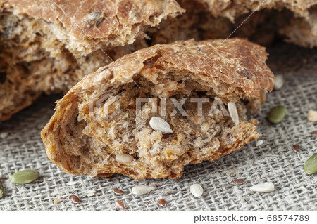 Uneven piece of multigrain bread, whole pumpkin seed, sunflower and flax seeds Uneven piece of multigrain bread, whole pumpkin seed, sunflower and flax seeds 68574789