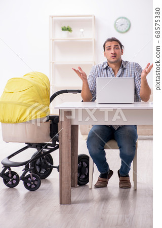 Young father looking after newborn baby at home 68575380