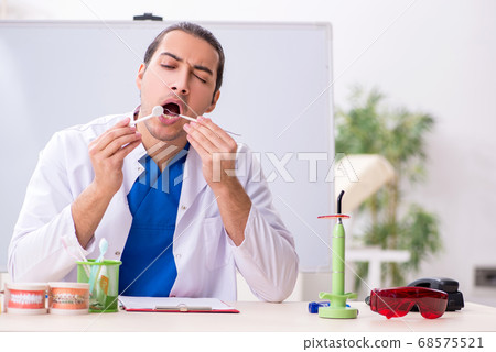 Young male dentist working in the clinic Young male dentist working in the clinic 68575521