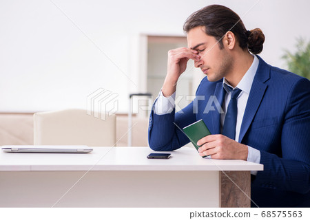 Young businessman holding passport preparing for trip 68575563
