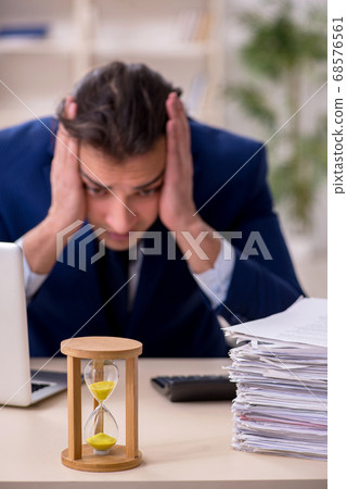Young male employee in time management concept 68576561