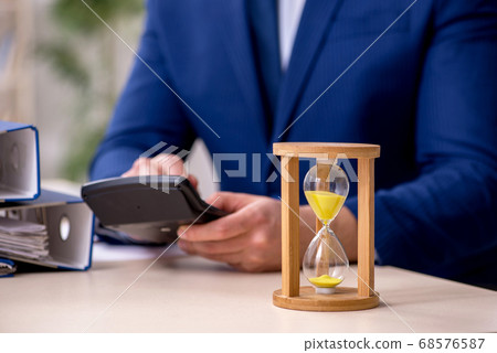 Young male employee in time management concept 68576587