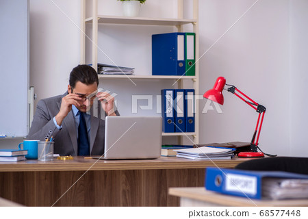 Young male businessman employee working in the office Young male businessman employee working in the office 68577448