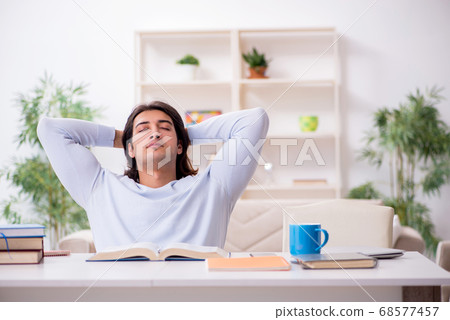 Young male student preparing for exams at home 68577457
