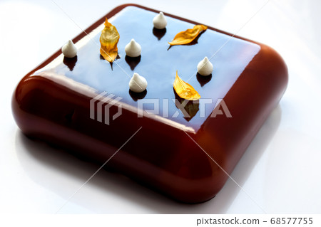 Square chocolate cake with yellow sunflower petals and little meringue kisses 68577755