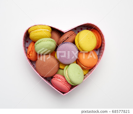 round baked multicolored macarons lie in a red 68577821