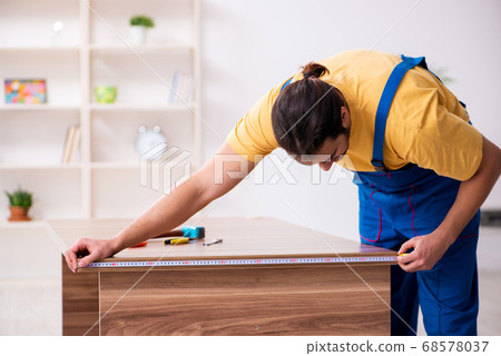 Young male carpenter working indoors Young male carpenter working indoors 68578037