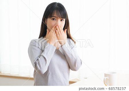 Young woman hiding mouth 68578237