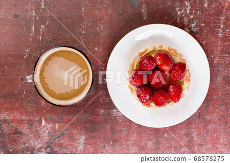 Strawberry shortcake and cup of coffee on old wooden table. Strawberry shortcake and cup of coffee on old wooden table. 68578275