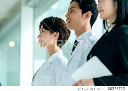 一名白大褂的醫生和一名穿著西裝的MR女人在醫院排隊 一名白大褂的醫生和一名穿著西裝的MR女人在醫院排隊 68578715