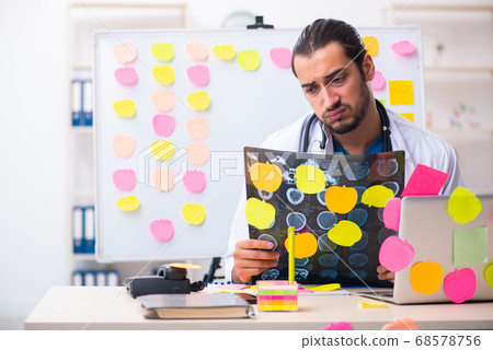 Young male medic in conflicting priorities concept 68578756