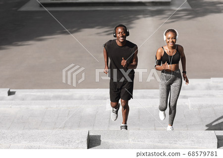 Couple Activities. Sporty Man And Woman Running Up Steps In Urban Park Couple Activities. Sporty Man And Woman Running Up Steps In Urban Park 68579781